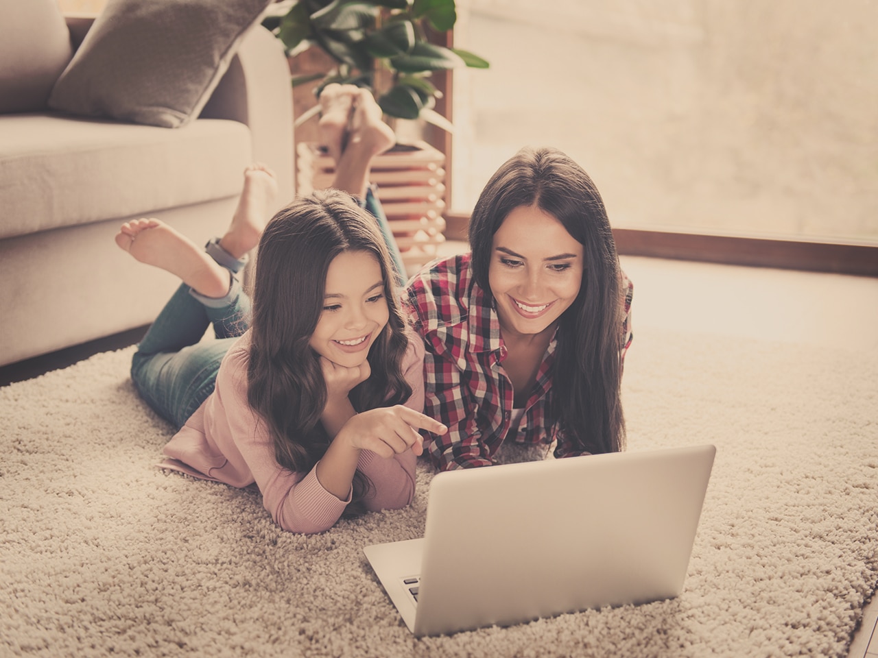 Mon and Child sitting on floor in front of a laptop